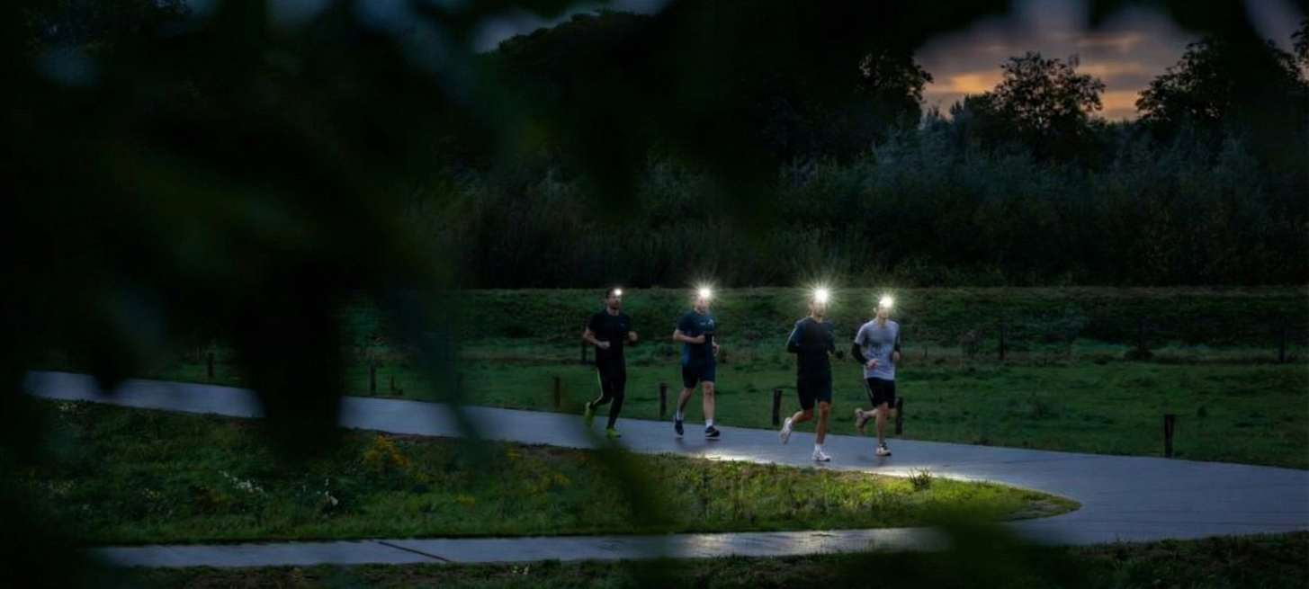 Sfeerbeeld van de Night Run met lopers en hoofdlampen in Park Lingezegen